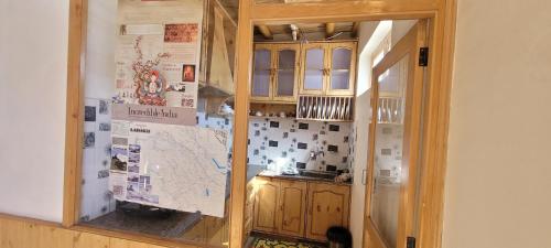 a kitchen with wooden cabinets and a glass door at Achina in Leh