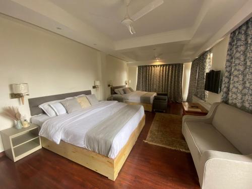 a hotel room with a large bed and a couch at Yarab Tso in Leh