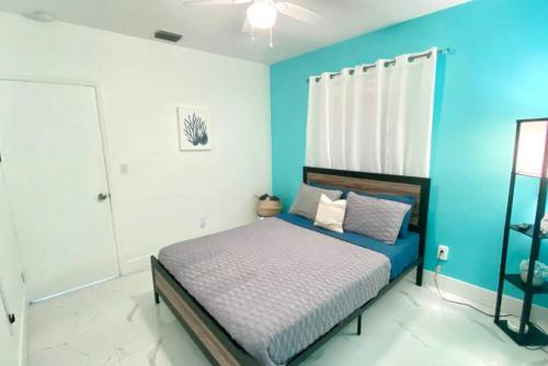 - une chambre dotée d'un lit avec un mur bleu dans l'établissement Peaceful Beachy Oasis 10 Mins from Beaches, à North Miami Beach