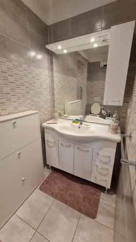 une salle de bain avec un lavabo et un miroir dans l'établissement Le Mentonnais - Appartement Carré d'Or Menton, à Menton