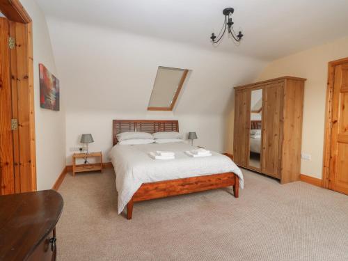 a bedroom with a bed and a mirror and a dresser at Lackamore in Lahinch