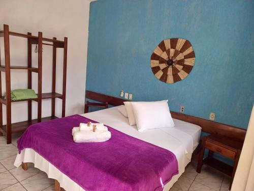 a bedroom with a bed with towels on it at Pousada Flor de Lotus in Itacaré