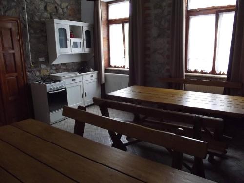 uma cozinha com uma mesa de madeira e dois bancos em Öreg Diófa Vendégház em Abaújszántó