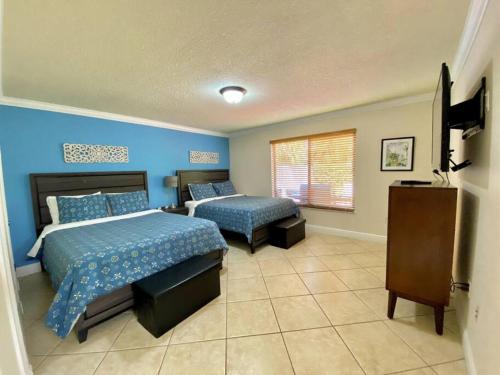 a bedroom with two beds and a flat screen tv at Tropical Oasis home w Community Pool great area in Kendall