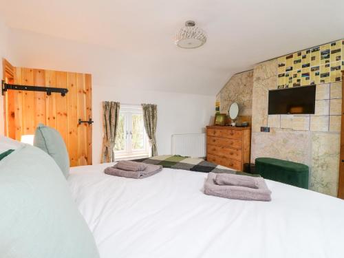 a bedroom with a large white bed and a tv at Valley View in Ashbourne