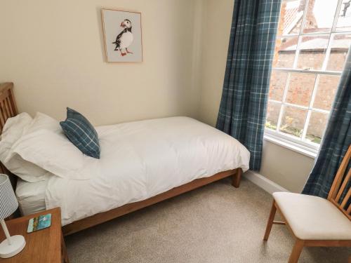a small bedroom with a bed and a window at Charter's Cottage in Berwick-Upon-Tweed