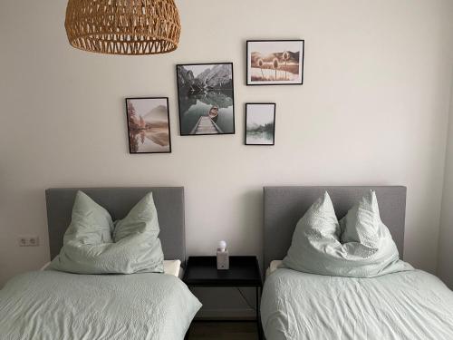 two beds in a room with pictures on the wall at Dream Apartments in Hohenems