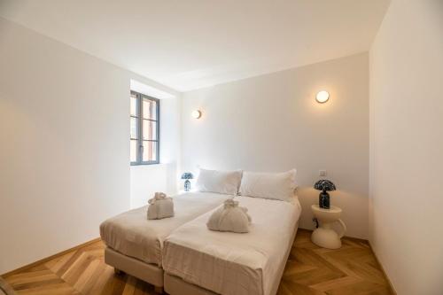a bedroom with a bed with two stuffed animals on it at Résidence Côté Sud in LʼÎle-Rousse