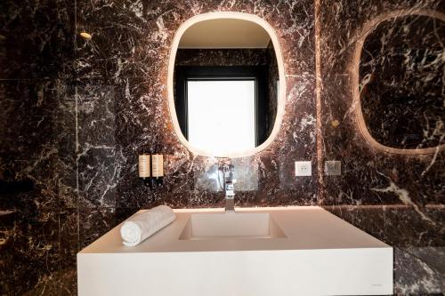 a bathroom with a sink and a mirror at Résidence Côté Sud in LʼÎle-Rousse