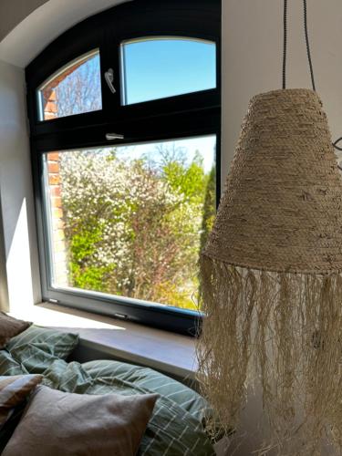 a bedroom with a window and a rattan lamp at Ublik Stacja in Ublik