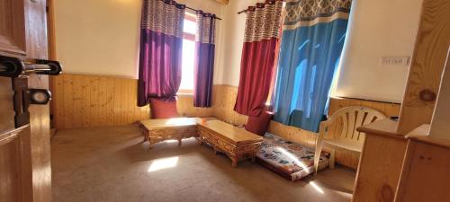 a room with a bench and some windows at Achina in Leh