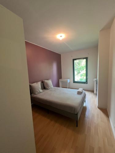 um quarto com uma cama e uma janela em Charment Appartement T3 Palaiseau Camille Claudel em Palaiseau
