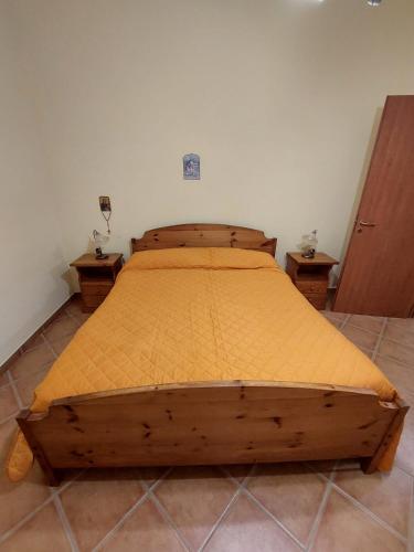 a wooden bed in a bedroom with two night stands at Tenuta Armida Relax & Pool in Liberi
