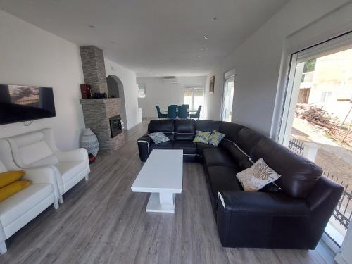 a living room with a black leather couch and a table at Harmony house in Bar