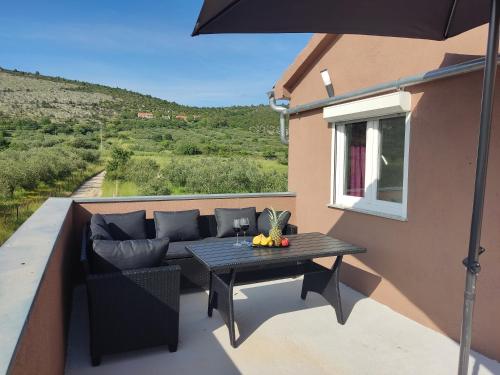 a patio with a couch and a table on a balcony at Holiday House Mablo with pool & jacuzzi in Šibenik