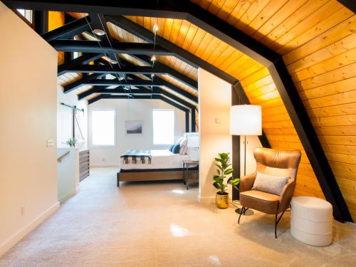 a living room with a wooden ceiling and a chair at Alpine Lodge in Glacier