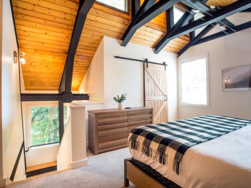 a bedroom with a bed and a wooden ceiling at Alpine Lodge in Glacier