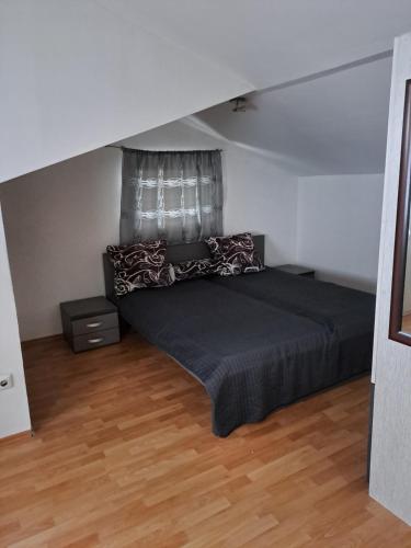 um quarto com uma cama com um cobertor preto e almofadas em Cool flat em Saraievo