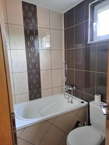 ein Bad mit einer Badewanne und einem WC in der Unterkunft Cool flat in Sarajevo