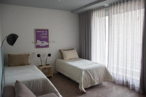 1 dormitorio con 2 camas y ventana en Casa Campus Palermo Cabrera en Buenos Aires