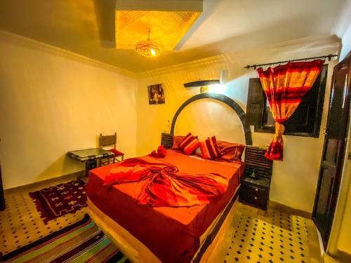 een slaapkamer met een rood bed in een kamer bij Riad Salma de Groot in Marrakesh