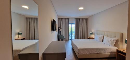 a hotel room with two beds and a window at Villa Rey Spa & Hotel in Vila de Rei
