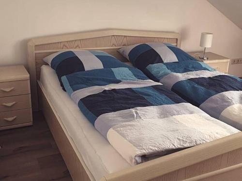 Una cama con edredones azules y blancos. en Oma Lina Haus - 4 SZ 2 Bäder großer Garten und Infrarot-Sauna en Greifenstein