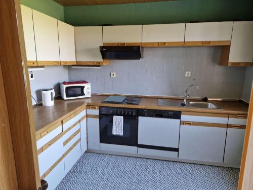 uma cozinha com armários brancos e um lavatório em Haus in Meinefeld em Nienstädt