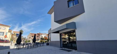 a building with chairs and umbrellas on a street at Villa Rey Spa & Hotel in Vila de Rei