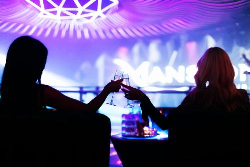 two people holding up a wine glass in a bar at Paradox Vancouver in Vancouver