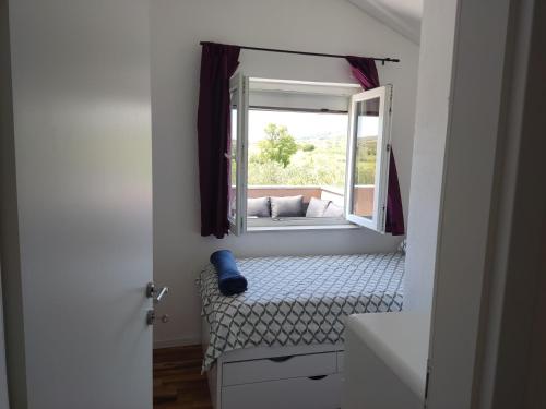 a small room with a bed and a window at Holiday House Mablo with pool & jacuzzi in Šibenik