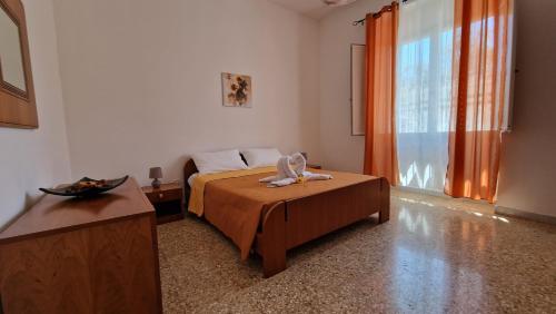 a bedroom with a bed and a table and a window at La campagna di Manuel in Tuglie