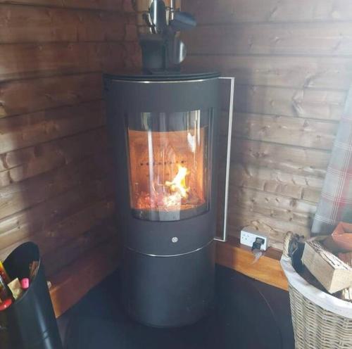 a stove with a fire in it in a room at Hillhaven Lodge in Inverness