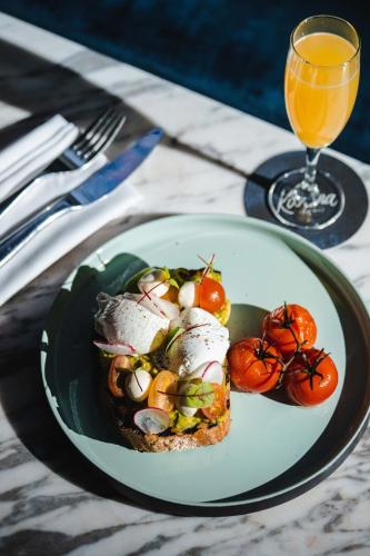 a plate with a sandwich and tomatoes on a table at Paradox Vancouver in Vancouver