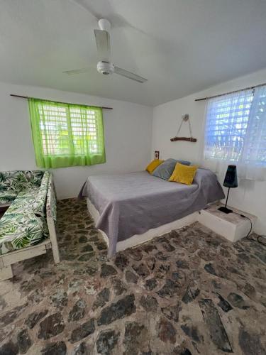 a bedroom with a large bed and two windows at El Patio Cultural in Las Terrenas