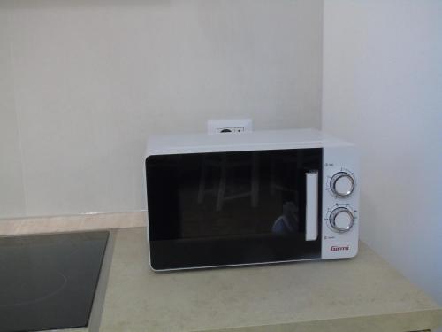 a microwave oven sitting on top of a counter at Casa Vacanza LiHele - Locazione Turistica in Castelsardo
