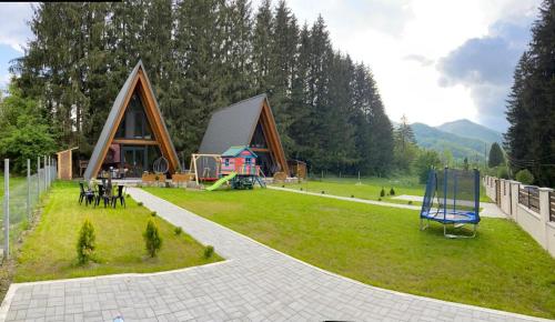 a house with a yard with a playground at Cabana Frame A Scorilo in Poiana Mărului