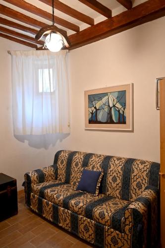 a living room with a couch and a window at IL TUFO E LA CASCATA in Pitigliano