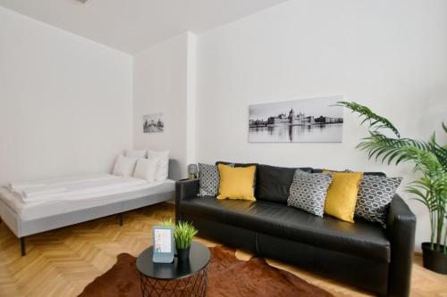 un soggiorno con divano nero e cuscini gialli di Standard Apartment by Hi5 - Petőfi 12 a Budapest
