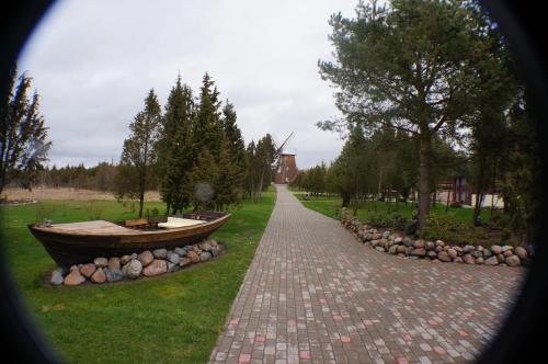 a brick walkway with a boat on the grass at Mardi Farm Stay in Karala