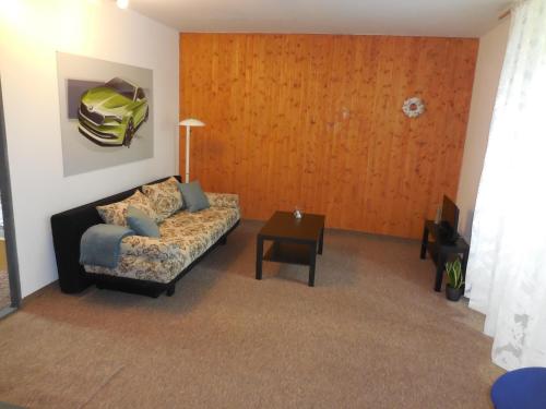 ein Wohnzimmer mit einem Sofa und einem Tisch in der Unterkunft Apartmán u zámku in Smečno
