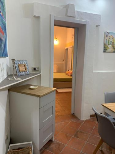 uma cozinha com um balcão e uma sala com um quarto em Casetta Lele Locazione breve em Siracusa