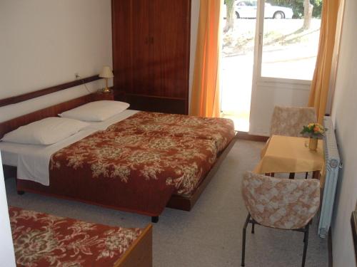 a bedroom with a bed and a table and a window at Depadansa Marina & Primorka in Omišalj