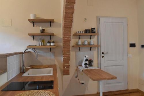 a kitchen with a sink and a white door at Claves Claustri - Camere in appartamento storico in Sarteano