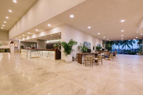 a lobby with a restaurant with tables and chairs at Sheraton Buganvilias Resort & Convention Center in Puerto Vallarta