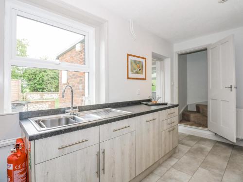 a kitchen with a sink and a window at Gamekeepers Cottage in Titchwell