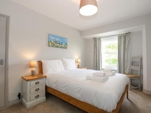 Schlafzimmer mit einem Bett mit weißer Bettwäsche und einem Fenster in der Unterkunft Gamekeepers Cottage in Titchwell