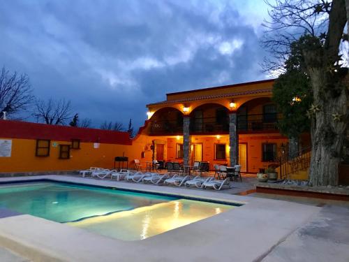 uma casa com piscina em frente a um edifício em HOTEL QUINTA SANTA CECILIA em Cuatrociénegas de Carranza