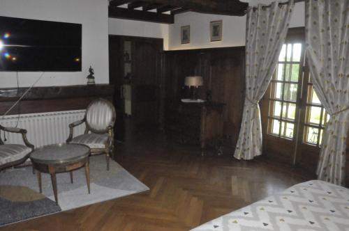 ein Wohnzimmer mit einem Bett, einem Tisch und Stühlen in der Unterkunft Château de St sauveur d'Emalleville in Émalleville