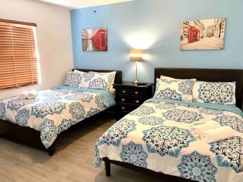 2 camas en un dormitorio con paredes azules en Home Sweet Home Near Malls and Airport and Hwy, en South Miami